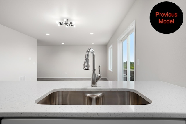 interior details featuring light stone counters and sink