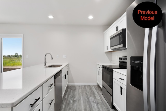 kitchen with sink, white cabinetry, kitchen peninsula, light hardwood / wood-style flooring, and stainless steel appliances