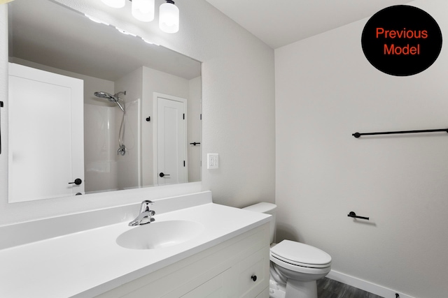 bathroom featuring hardwood / wood-style floors, a shower, vanity, and toilet