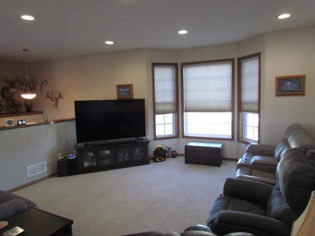 living room featuring an inviting chandelier and carpet floors