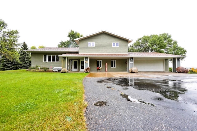 view of front of property with a garage, a porch, and a front lawn