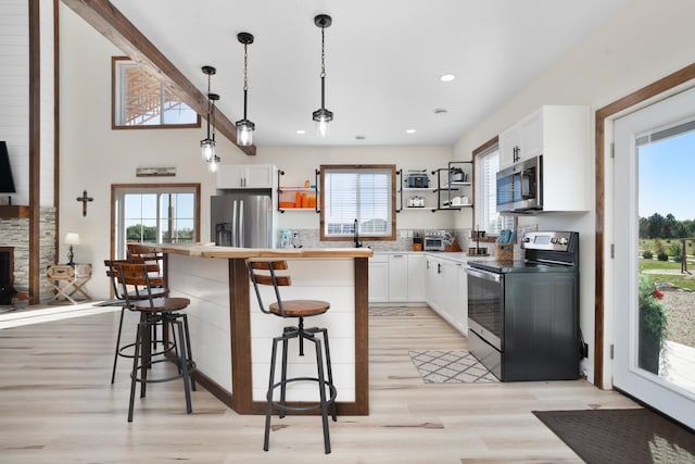 kitchen featuring appliances with stainless steel finishes, a healthy amount of sunlight, and white cabinetry