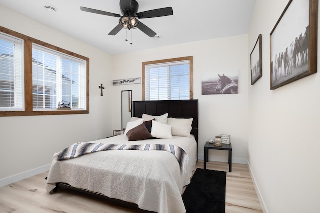 bedroom with multiple windows, ceiling fan, and light hardwood / wood-style flooring