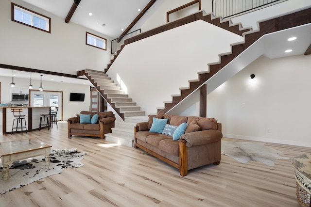 living room with light wood-type flooring and high vaulted ceiling