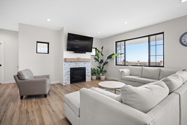 living room with light wood-type flooring and a fireplace