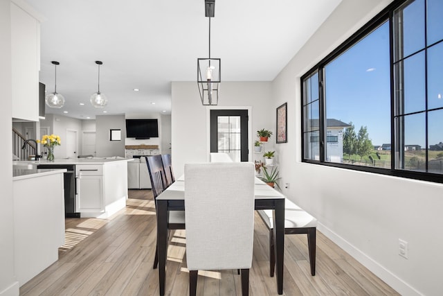 dining space featuring sink and light hardwood / wood-style floors