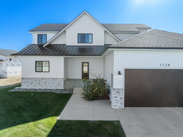 modern farmhouse style home with a front yard and a garage