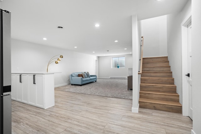 stairway featuring hardwood / wood-style floors and a baseboard heating unit