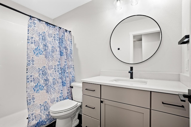 bathroom featuring curtained shower, vanity, and toilet