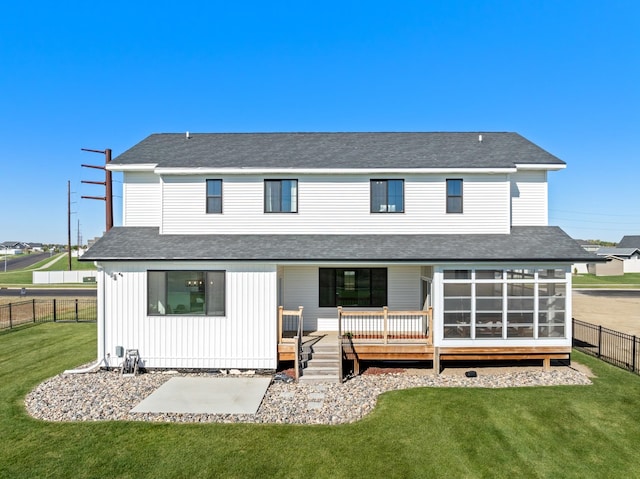 back of house with a deck, a yard, and a sunroom