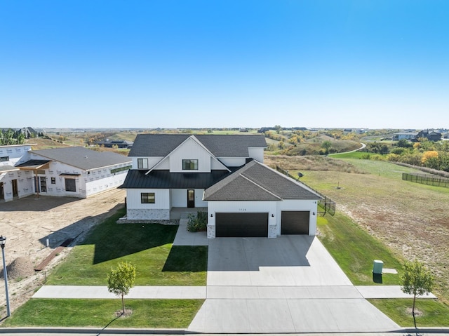 modern farmhouse style home featuring a front yard and a garage