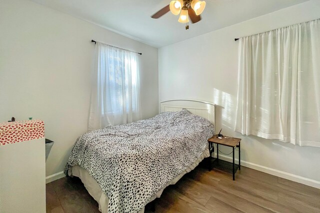 bedroom featuring wood finished floors, baseboards, and ceiling fan