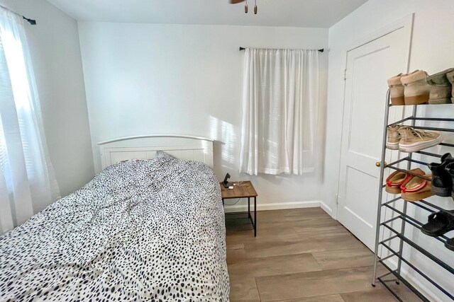 bedroom featuring baseboards and wood finished floors