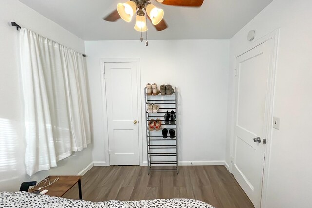 bedroom with ceiling fan, baseboards, and wood finished floors