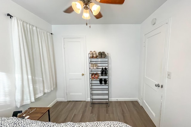 bedroom with ceiling fan, baseboards, and wood finished floors