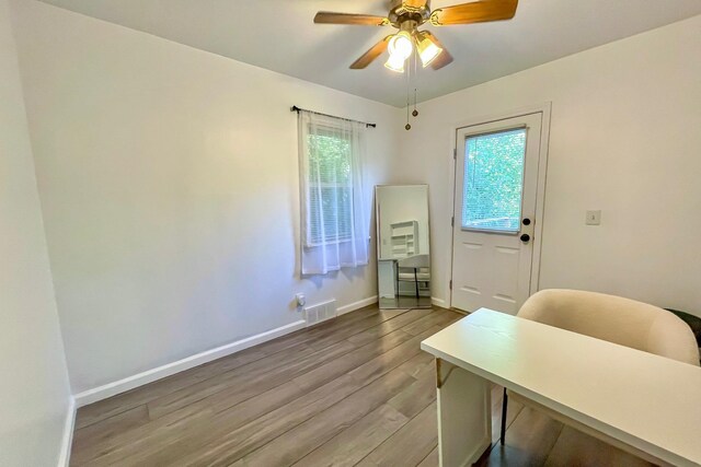 home office featuring visible vents, plenty of natural light, baseboards, and wood finished floors