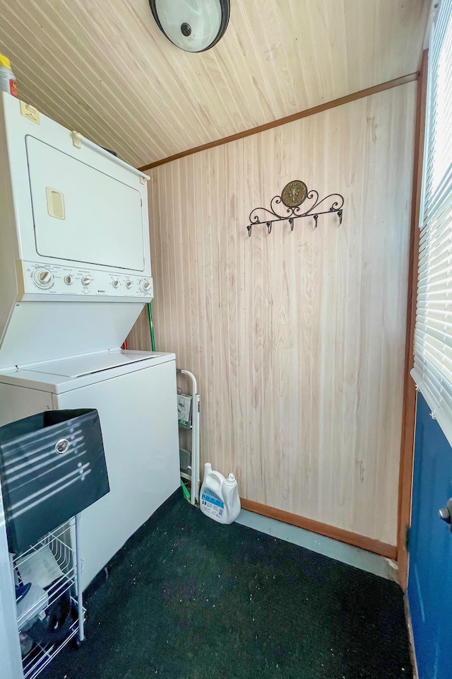 laundry room featuring wooden walls, carpet flooring, stacked washer and clothes dryer, and wooden ceiling