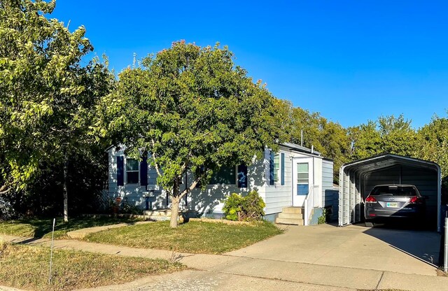 obstructed view of property featuring concrete driveway and a carport