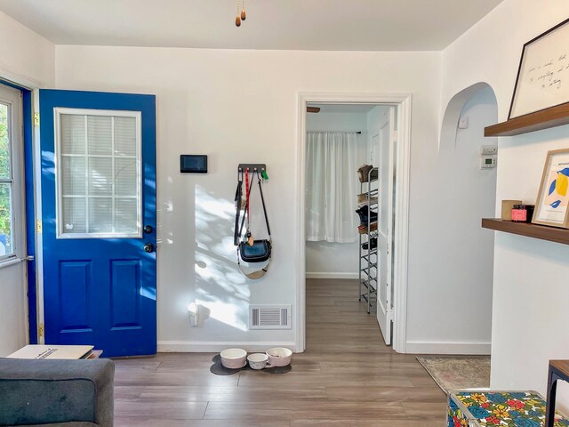 entrance foyer with wood finished floors, visible vents, and baseboards