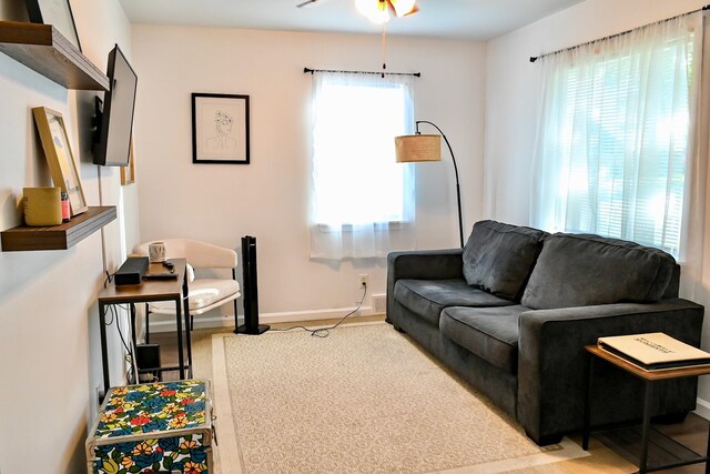 living room featuring baseboards and ceiling fan