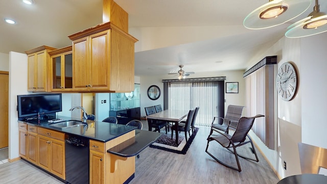 kitchen featuring ceiling fan, lofted ceiling, sink, light hardwood / wood-style flooring, and black dishwasher