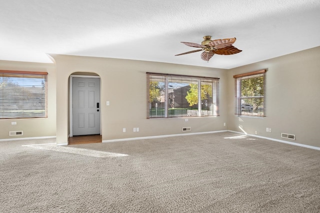 carpeted empty room featuring a textured ceiling and ceiling fan