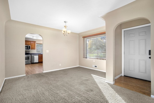 entrance foyer featuring an inviting chandelier and hardwood / wood-style flooring