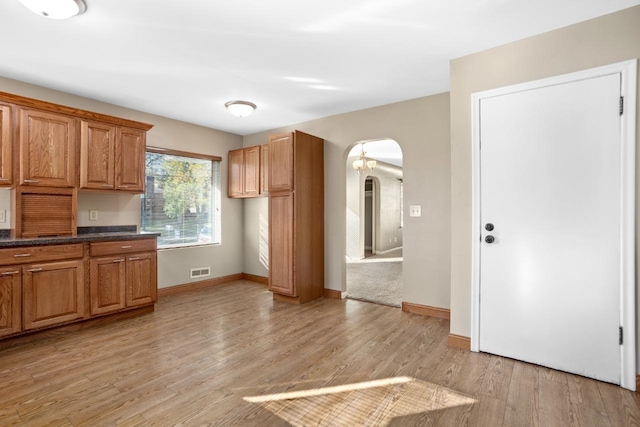 kitchen featuring dark stone counters and light hardwood / wood-style flooring