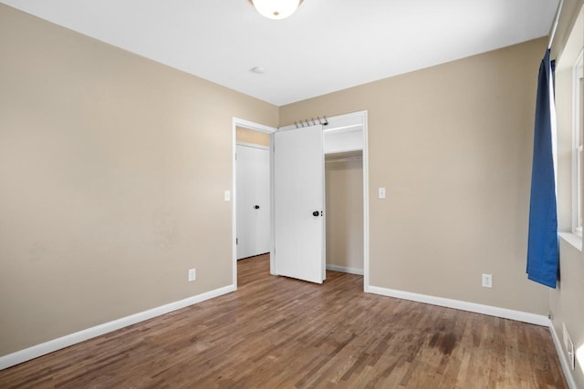 unfurnished bedroom featuring wood-type flooring and a closet