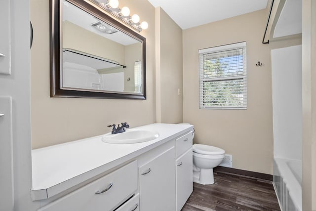 full bathroom with vanity, toilet, washtub / shower combination, and hardwood / wood-style flooring