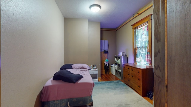 bedroom with ornamental molding and light hardwood / wood-style floors