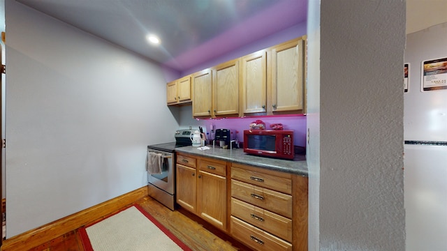 kitchen featuring stainless steel range with electric cooktop, light brown cabinets, white refrigerator, and light hardwood / wood-style floors