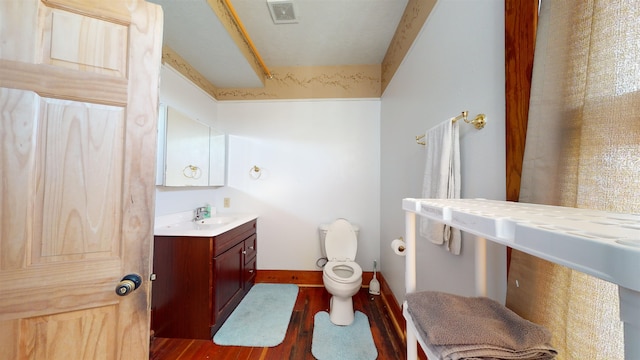 bathroom with wood-type flooring, vanity, and toilet