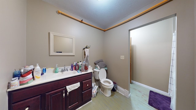 bathroom featuring vanity, walk in shower, hardwood / wood-style flooring, toilet, and a textured ceiling