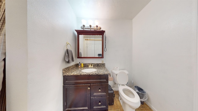 bathroom with vanity, tile patterned flooring, and toilet