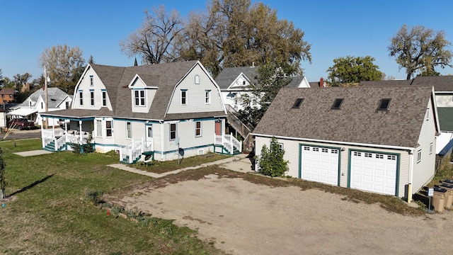 back of house with a garage, a yard, and covered porch