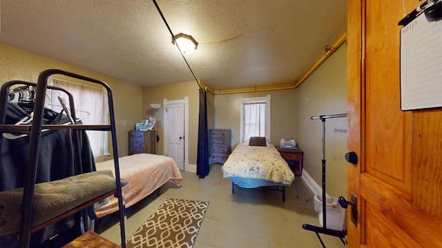 bedroom with hardwood / wood-style flooring and a textured ceiling