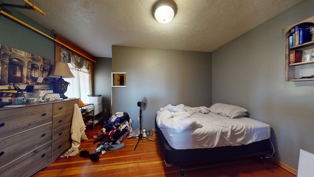 bedroom featuring wood-type flooring and a textured ceiling