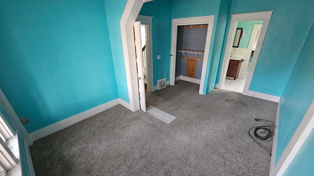 unfurnished bedroom with a closet and light carpet