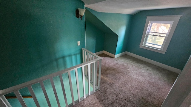 additional living space featuring a textured ceiling, carpet, and vaulted ceiling