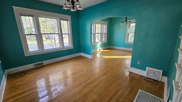 unfurnished dining area with a chandelier and light hardwood / wood-style floors