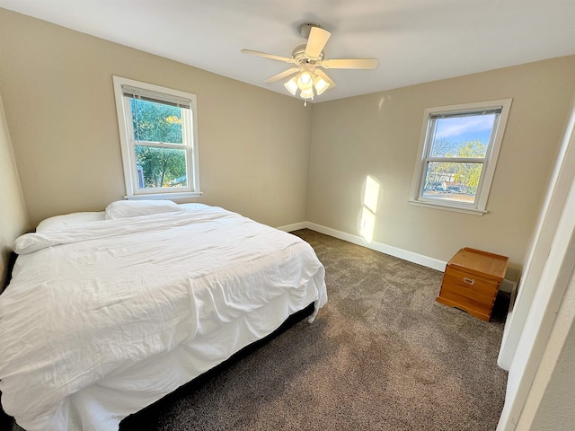 carpeted bedroom featuring multiple windows and ceiling fan