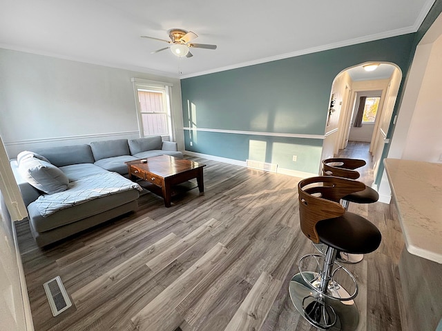 living room featuring a healthy amount of sunlight, ceiling fan, hardwood / wood-style flooring, and crown molding