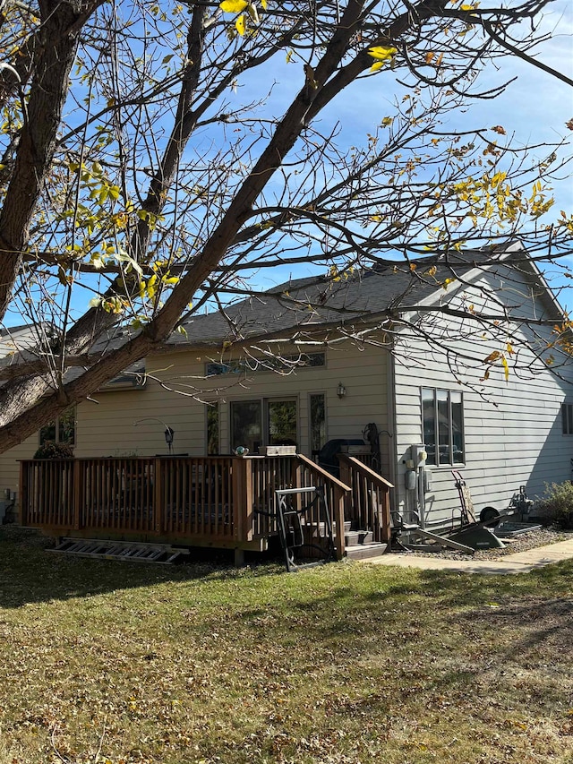 back of property featuring a lawn and a wooden deck