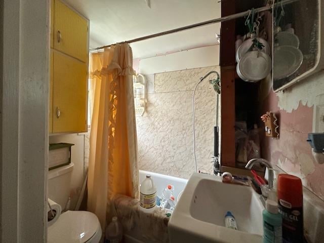 full bathroom with shower / tub combo with curtain, sink, and toilet