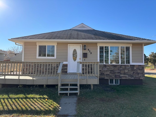 view of front facade with a wooden deck and a front yard