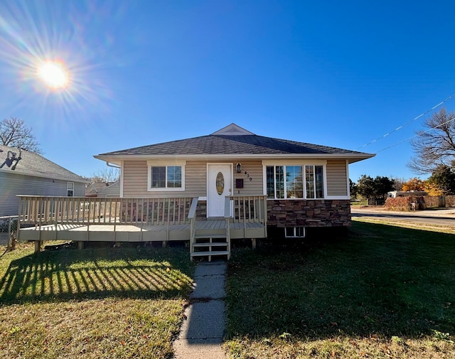 view of front of property with a front yard and a deck