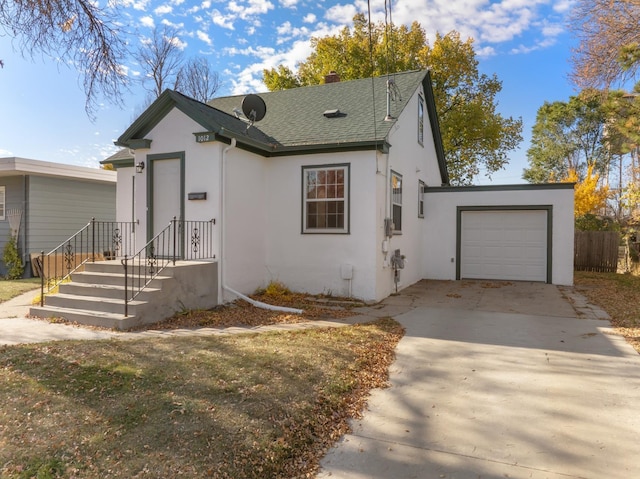 1012 4th St, Minot, ND 58701 - bungalow-style home featuring an attached garage, a shingled roof, stucco siding, and concrete driveway