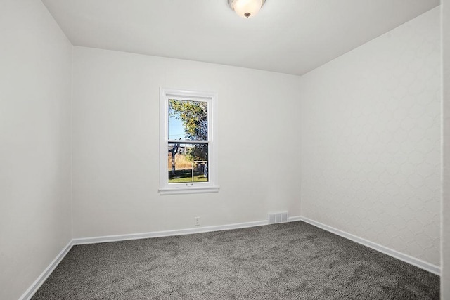 1012 4th St, Minot, ND 58701 - unfurnished room with visible vents, baseboards, and dark carpet