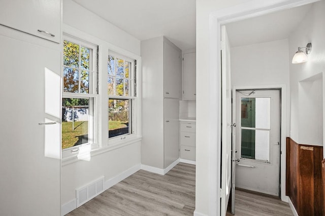 hallway with light hardwood / wood-style floors